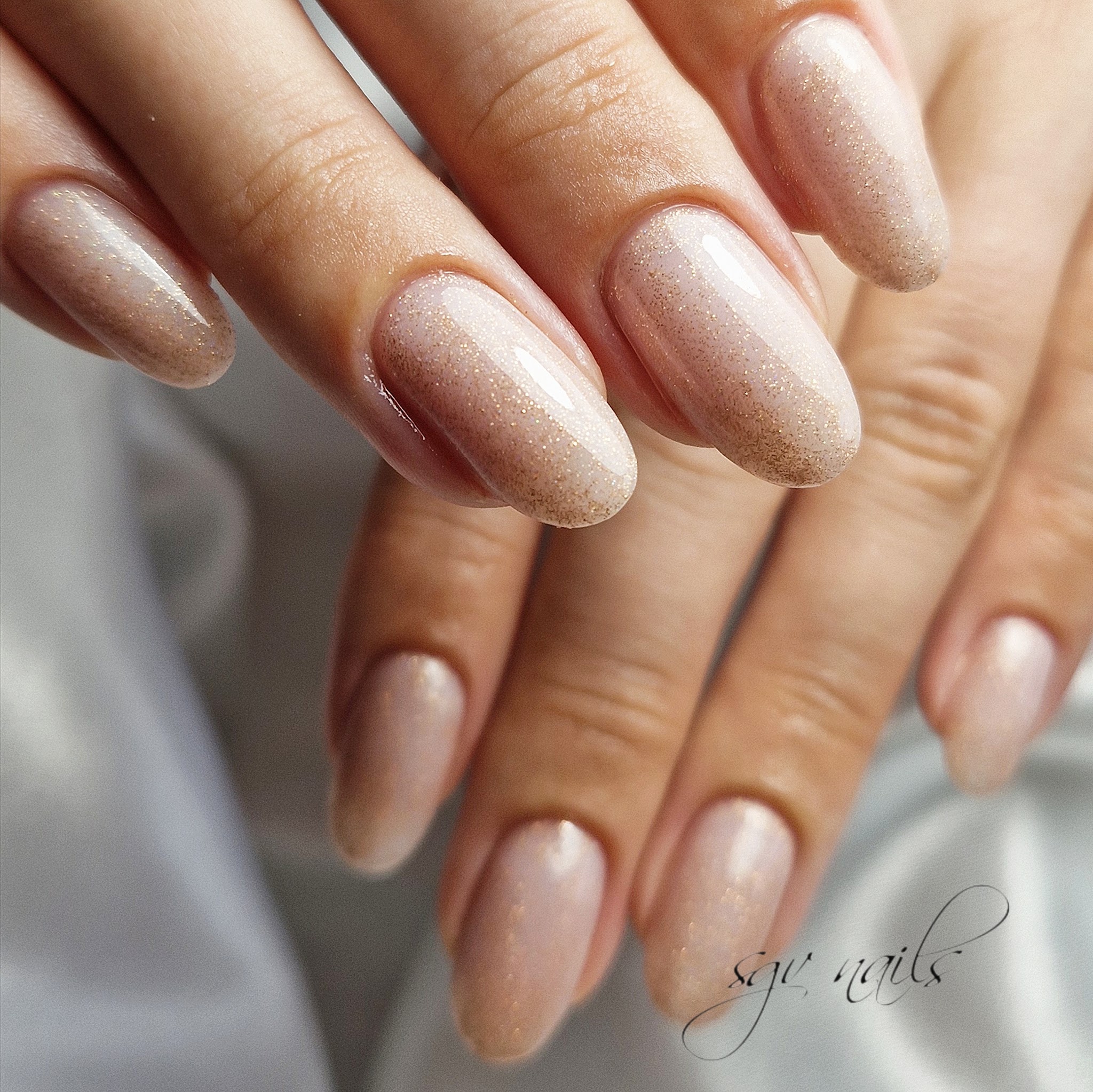 Lange amandelnagels in champagne met fijne glitter