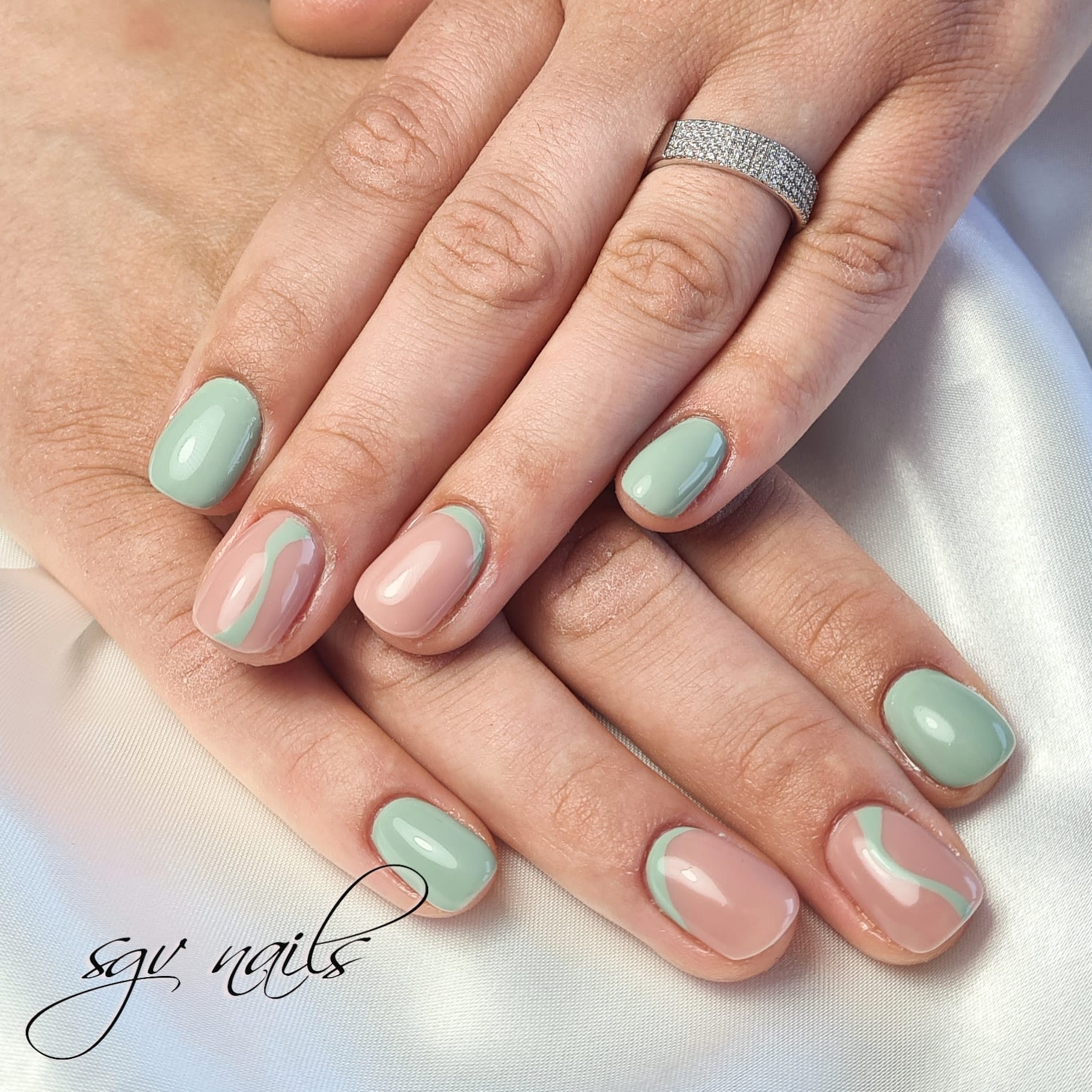 Korte nagels in mint, met nude nagels en mint en roze golfjes